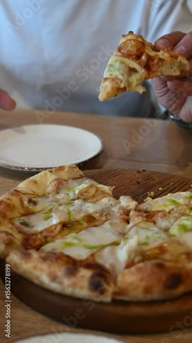 Close-up of male hand taking slice of hot cheesy pizza. Stretching melted cheese, delicious and appetizing scene in restaurant. Concept of fast food, dining