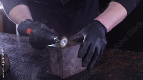 A closeup of a professional using a grinder on metal, showcasing exceptional craftsmanship in a workshop.