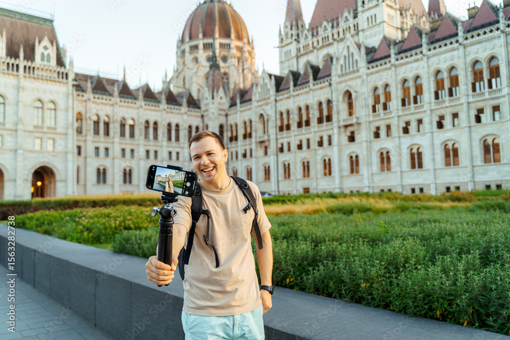 Fototapeta premium Smiling Travel Blogger Recording Vlog in Front of Historic Building