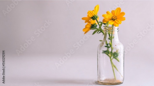 Minimalist wildflower arrangement in a vintage glass bottle on neutral background, soft pastel tones, perfect for wellness or editorial, with space for text.