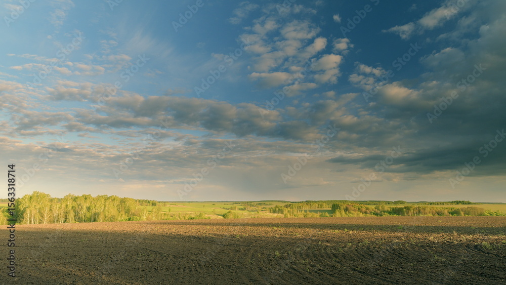 Obraz premium Experience a breathtaking and serene landscape featuring rolling fields and dramatic skies Time lapse.