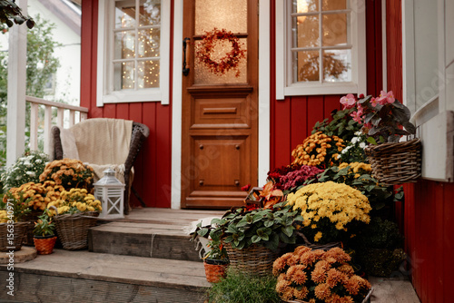 Canvas-taulu Front porch of village house decorated with autumn flowers and plants, wooden st