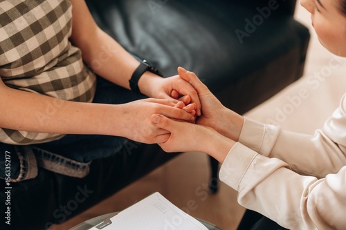 Support conception. Close up view of woman psychologist that is supporting young girl by holding her hands