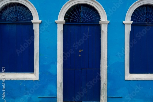 Vibrant blue colonial facade with arches.