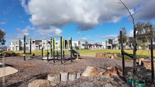 Outdoor playground in a new suburban estate in an outer suburb of Australia.  Landscaped greenery and modern homes. Public family-friendly space. Contemporary urban planning and livable community