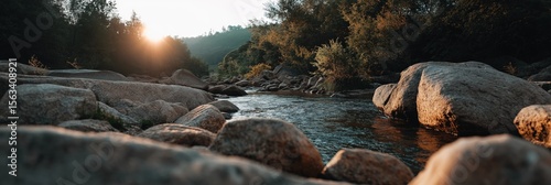 Scenic river at sunset with rocks and lush forest landscape