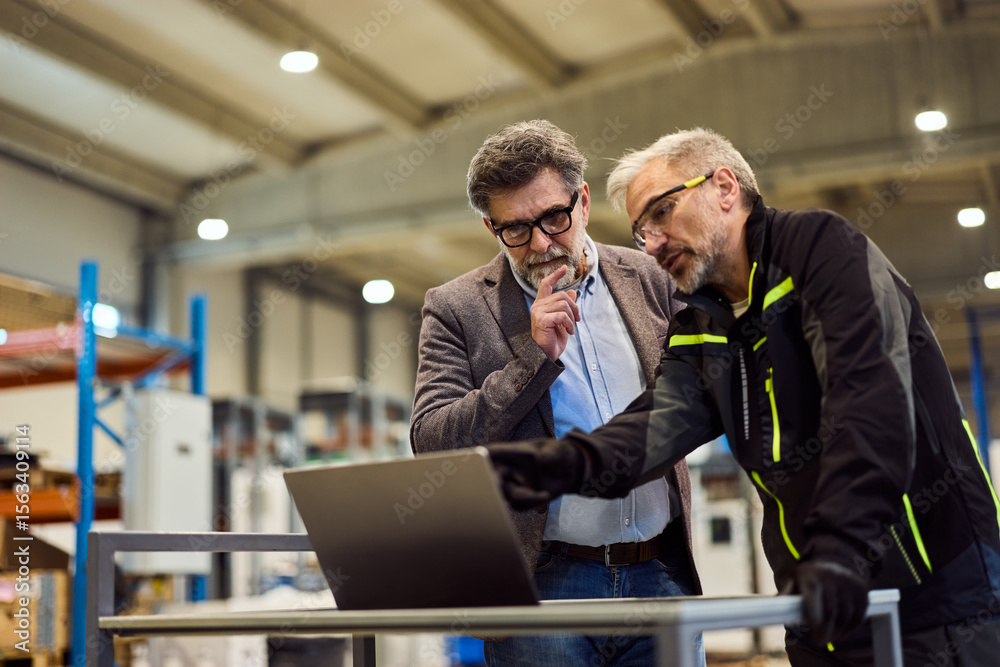 Two Male Professionals Collaborating in an Industrial Setting With Focus on Innovation Two Male Professionals Collaborating in an Industrial Setting With Focus on Innovation
