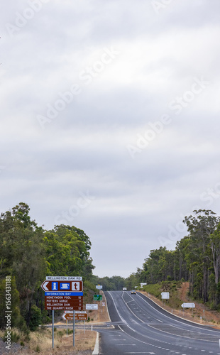 many signs on the highway at tourist attraction turn-off