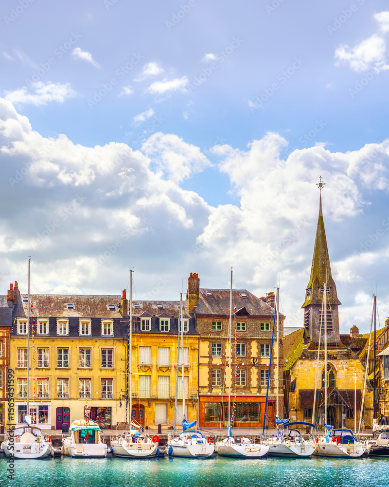 Fototapeta premium Honfleur village, buildings, church, and sailboats in the harbor. Normandy, France