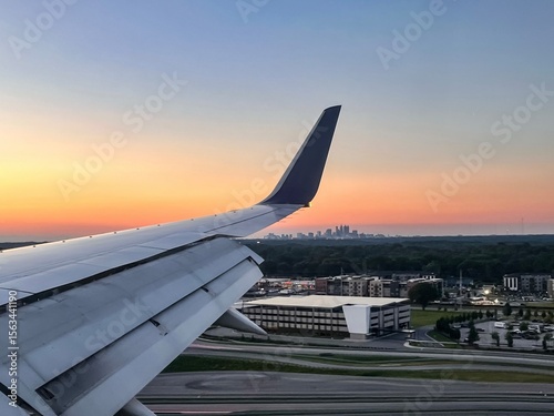 Plane lands at the Hartsfield-Jackson International Airport during Sunset with Atlanta’s skyline visible in the background