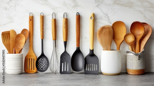 Set of wooden and silicone kitchen utensils organized in ceramic holders