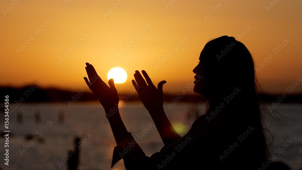 Εκτύπωση καμβά Woman worshipping god at sunset with open arms