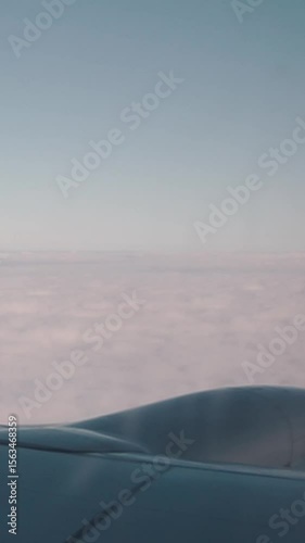 View from above on the horizon and high mountains with snow and clouds. Flight in the sky on a large passenger liner during travel and vacation. Airplane window and wing in the air
