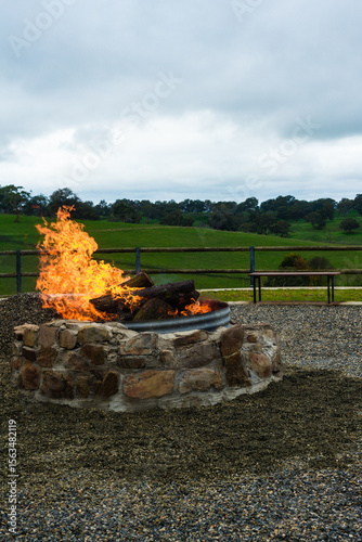 Stone outdoor fire pit with blazing fire