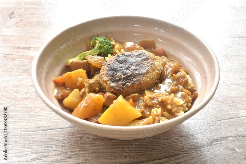 hamburg crispy fried chop pork with boiled vegetable topping plain rice dressing potato and carrot in Japanese curry on bowl