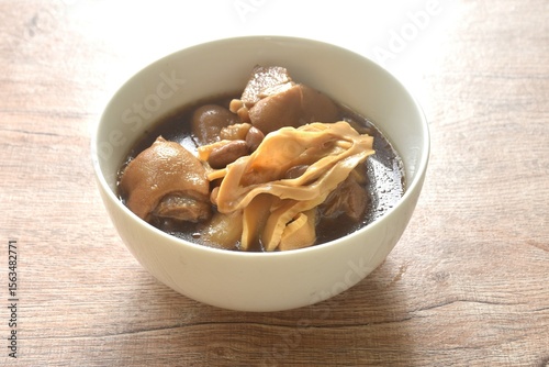 boiled slice Chinese bamboo shoot with pork leg and peanut in clear soup on bowl