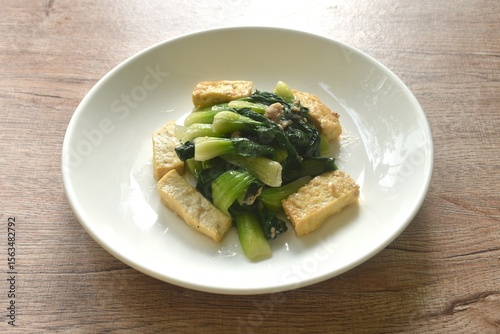 stir fried Chinese cabbage with slice tofu and chop pork in soy sauce on plate