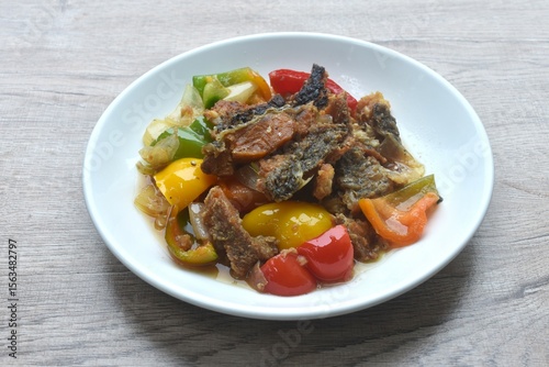 deep fried slice mango fish with bell pepper and onion in black pepper sauce on plate 