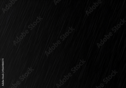 Rain streaks on a dark surface. Abstract diagonal rain streaks across a black background. Weather pattern for graphic design or website use. No people or objects.