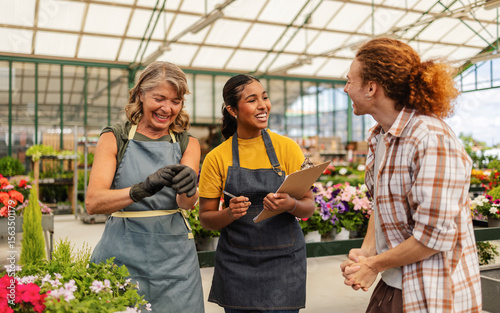 People interacting in a greenhouse with plants and flowers