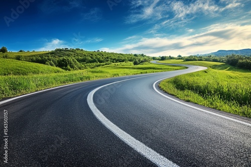 Fototapeta Naklejka Na Ścianę i Meble -  Winding asphalt road through green countryside landscape under blue sky with white clouds, travel and adventure concept