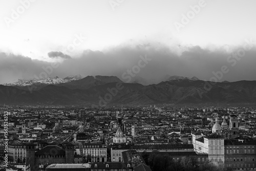 Black and white photo showing the cityscape of Turin surrounded by the Alps in Italy