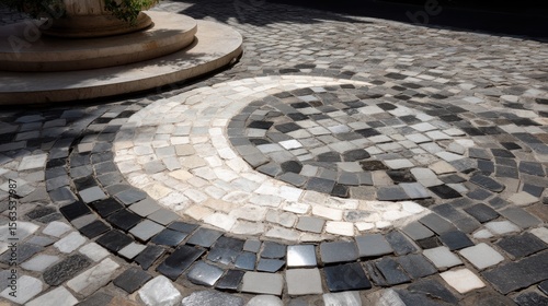 Circular stone mosaic pattern on outdoor cobblestone pavement