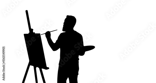 Silhouette of an artist standing in front of an easel holding a paintbrush and a palette in black