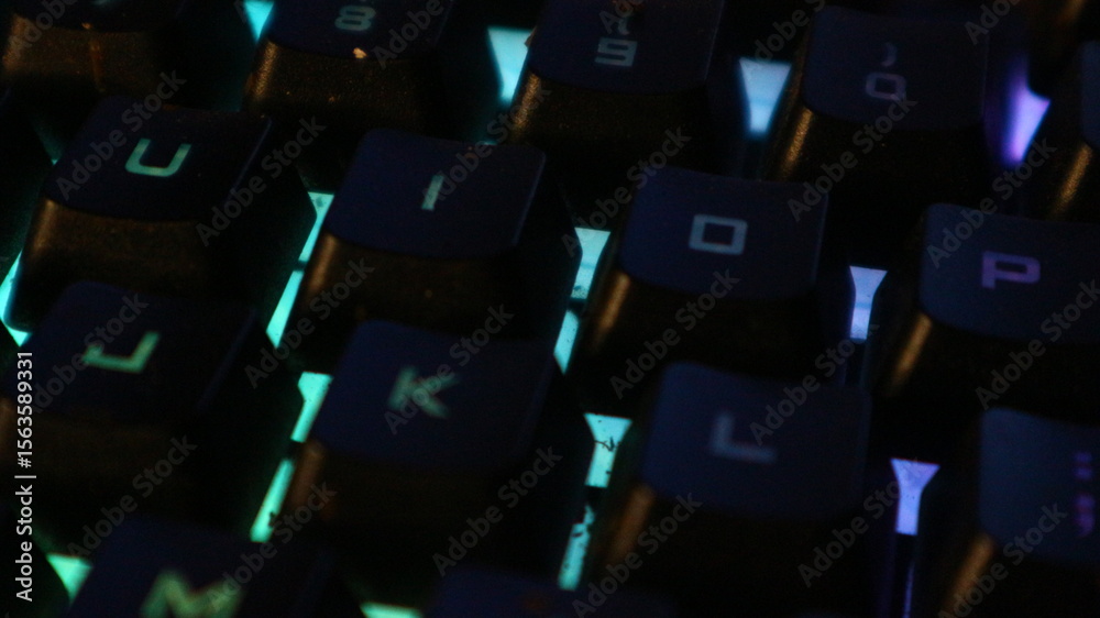 Fototapeta premium Close-up view of illuminated keyboard keys, showing colorful backlighting.