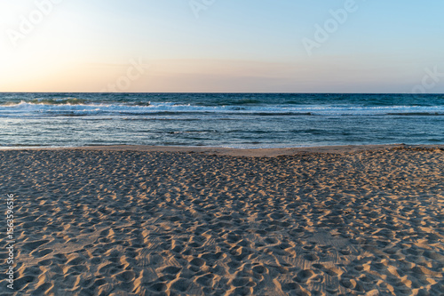 Fototapeta Naklejka Na Ścianę i Meble -  Sunset beach view in Crete, Greece with gentle waves and sandy shoreline