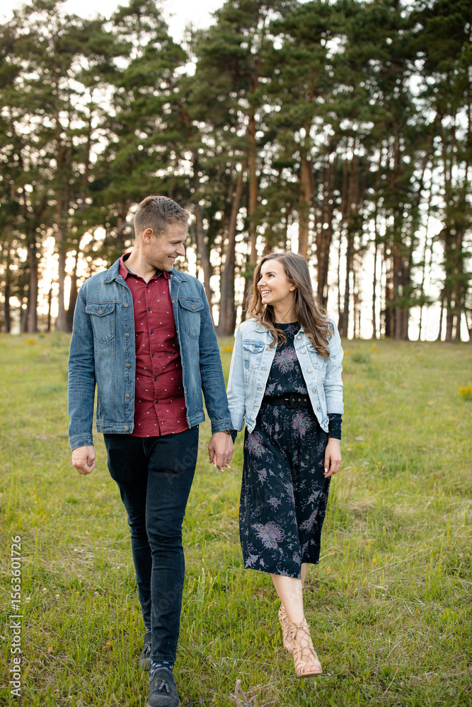 Fototapeta premium Couple strolling through scenic forest landscape