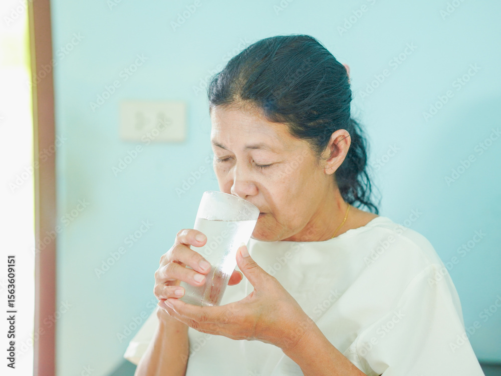 Senior Asian woman drinking water glass in morning, Healthy Lifestyle people for routine, nutrition, hydration body care and health care. Elderly care wellness health. Female beverage anti aging Senior Asian woman drinking water glass in morning, Healthy Lifestyle people for routine, nutrition, hydration body care and health care. Elderly care wellness health. Female beverage anti aging