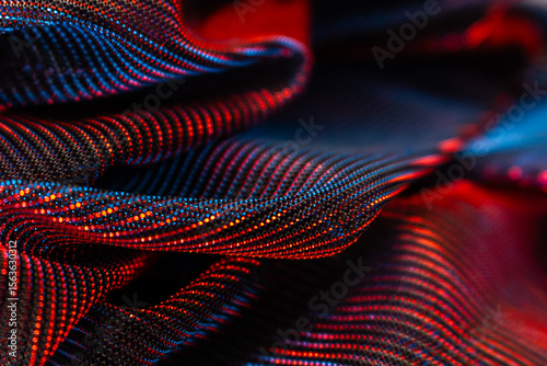 Futuristic close-up of glowing, folded mesh or textile with vibrant red and blue dots in wave patterns – abstract high-tech surface for digital design, innovation, or modern textile concepts