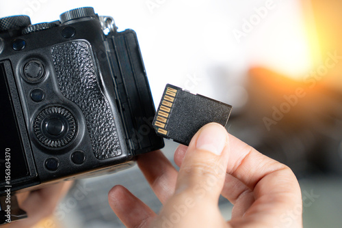 Close-up of hand removing memory card from camera, symbolizing digital workflow and image storage.