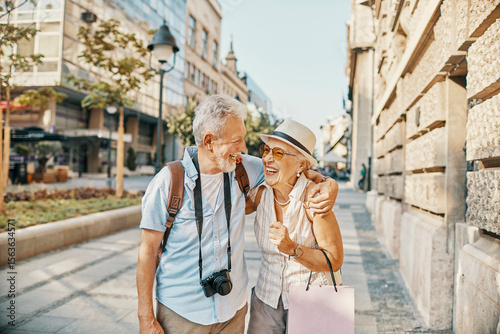 Happy senior couple sightseeing and laughing together in the city