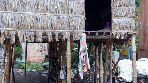 The basement of the stilt houses built by the Bajau people is built on the cluttered seashore of the Philippines, featuring bamboo and log supports.