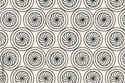 A black and white repeating pattern of spirals, creating a hypnotic and dynamic visual effect.