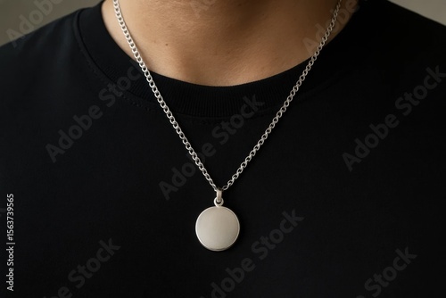 A man wearing a black shirt and a silver necklace
