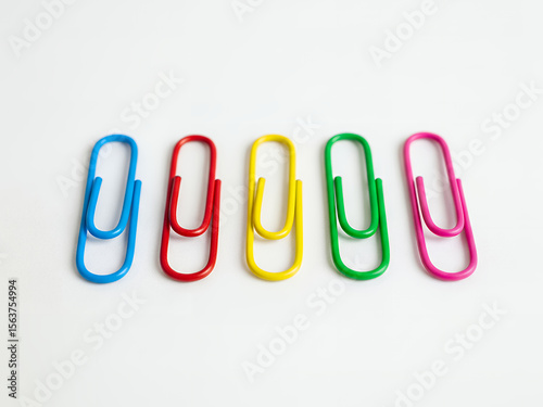 A Collection of Colorful Paper Clips Arranged in a Row on a White Background