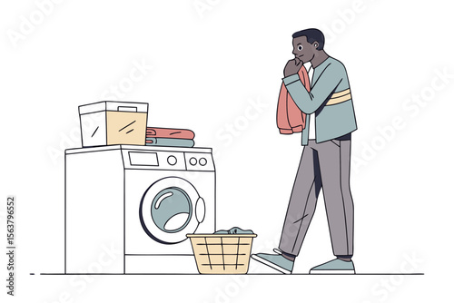 Man contemplating laundry day with a washing machine basket of clothes and folded garments nearby