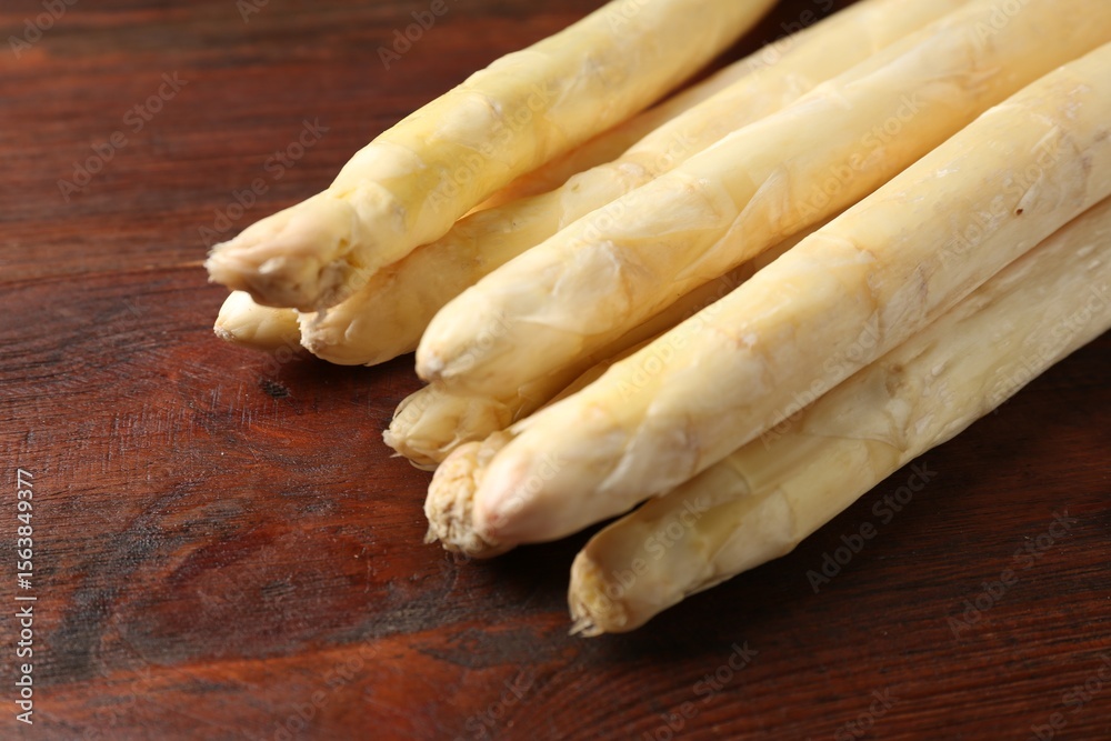 Fototapeta premium Many raw asparagus spears on wooden table, closeup. Space for text