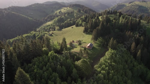 Aerial view of the Transylvanian village in the mountains, during summer. Sunset scene over the mountain valley in the Carpathian Mountains