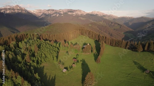 Aerial view of the Transylvanian village in the mountains, during summer. Sunset scene over the mountain valley in the Carpathian Mountains