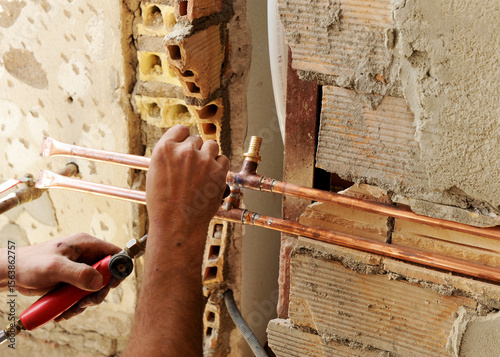 Konstfotografi The hands of a plumber while soldering to connect copper pipes during the renovation of the water supply installations in a house