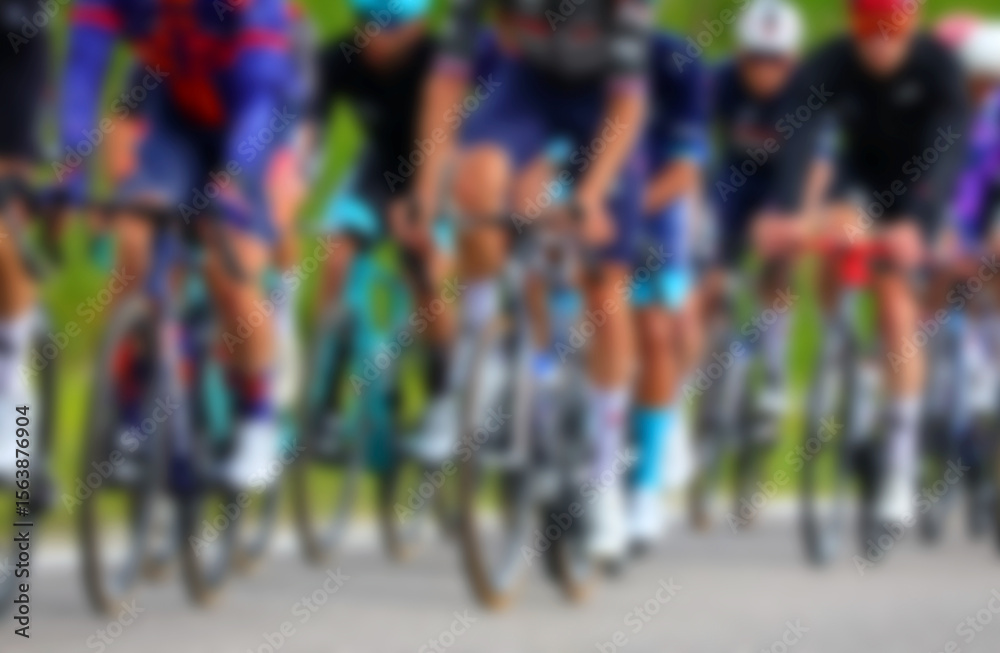 Fototapeta premium Intentionally blurred group of many professional cyclists energetically pedaling on racing bikes during a competitive race