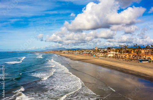 Papier peint Aerial view of the Pacific Ocean coastline of Oceanside, California with clouds and blue skies