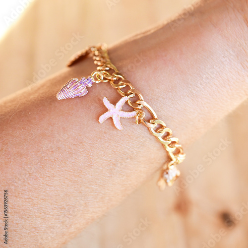 Tablou pe pânză Close up charm bracelet on womans wrist beach theme charm bracelet jewelry