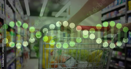 Woman pushing cart down store aisle, dots forming twisting helix over produce showing nutrients