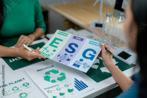 Businesswomen discussing about esg report with environmental, social, and governance icons during a meeting