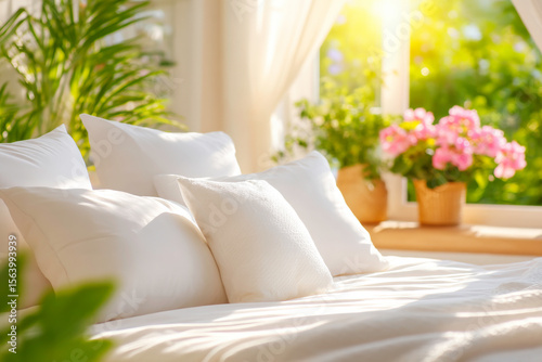 Morning scene with messy rumpled white bedclothes and soft pillows in sunlight